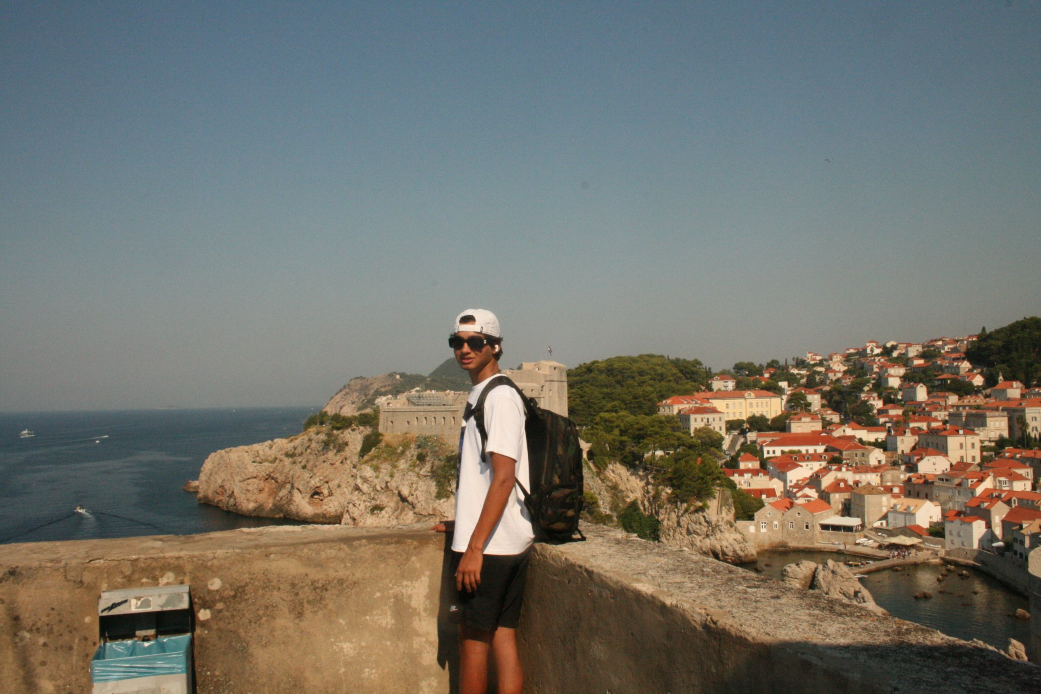 A traveler enjoying the view of Dubrovnik's old city walls and the Adriatic sea.